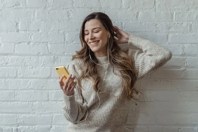 Mosolygó nő a telefonját nézi